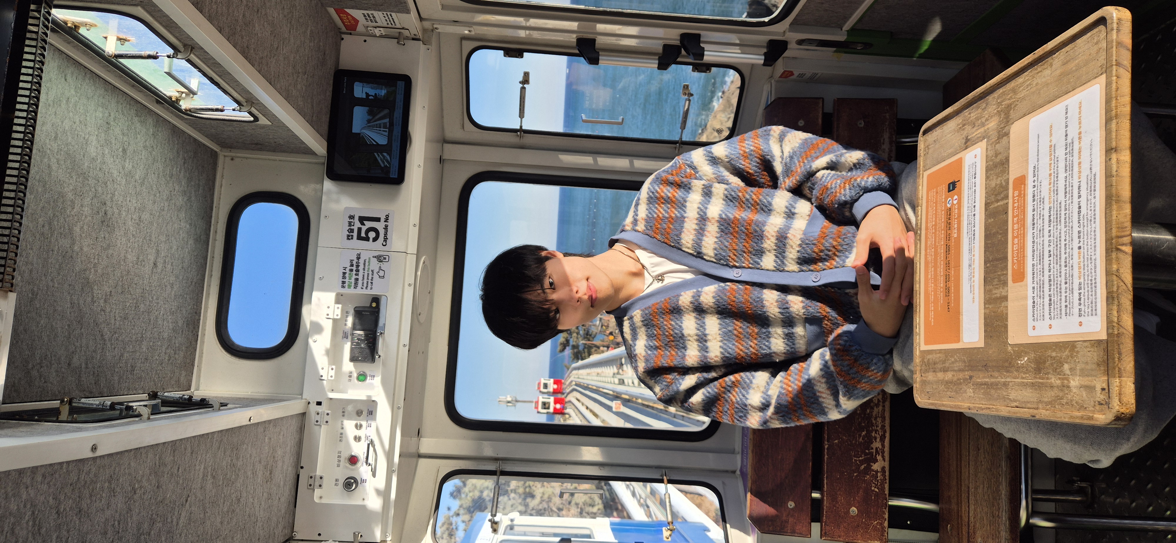 Kyeong-Rae Kim sitting in a seaside capsule train.